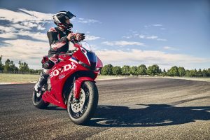 Fahrer auf der stehenden Honda CBR600RR 2027 in Ignition Red HRC TriColour auf der Rennstrecke