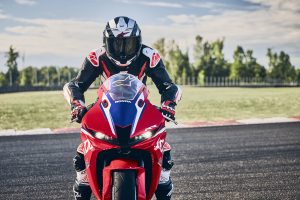 Honda CBR600RR 2027 in Ignition Red HRC TriColour frontal mit Fahrer und LED-Doppelscheinwerfern auf der Strecke