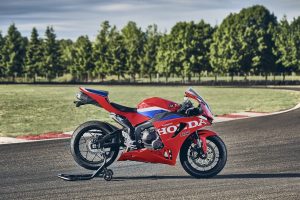 Honda CBR600RR 2027 in Ignition Red HRC TriColour auf Montageständer an der Rennstrecke, Seitenansicht von rechts