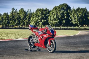 Honda CBR600RR 2027 in Ignition Red HRC TriColour auf Montageständer, Dreiviertelansicht von vorne rechts