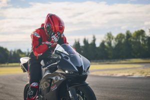 Fahrer klappt das Visier zu auf der Honda CBR600RR 2027 in Matt Ballistic Black Metallic