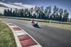 Honda CBR600RR 2027 mit Fahrer in voller Fahrt auf der Zielgeraden, weite Perspektive mit Curbs