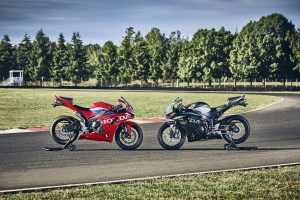 Honda CBR600RR 2027 in Ignition Red HRC TriColour und Matt Ballistic Black Metallic nebeneinander an der Rennstrecke