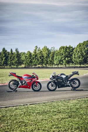 Honda CBR600RR 2027 in Rot und Schwarz nebeneinander an der Rennstrecke, Hochformat