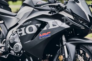 Honda CBR600RR 2027 in Matt Ballistic Black Metallic – Detail der Seitenverkleidung mit Honda-Schriftzug und HRC-Logo