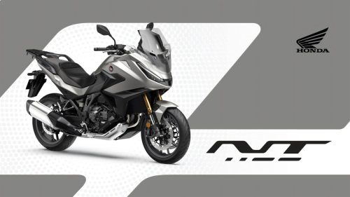 Honda NT1100 2027 in Mat Beta Silver Metallic – Dreiviertelansicht von vorne mit Doppel-LED-Scheinwerfern und Seitenkoffern, Studiografik mit Honda-Logo