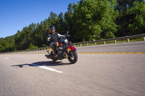 Fahraufnahme von schräg vorn auf einem Highway durch die Black Hills unter wolkenlosem Himmel
