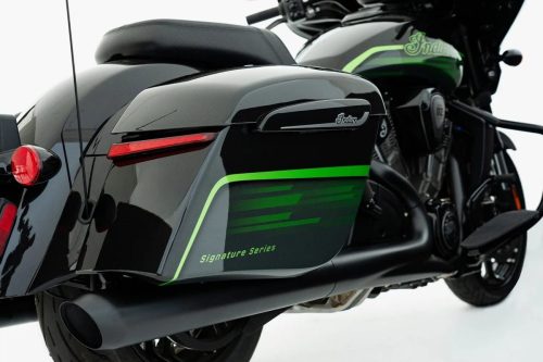 Detailaufnahme der Satteltasche der Indian Chieftain PowerPlus Signature Series 2026 mit grünem „Signature Series-Schriftzug und Indian-Logo, im Hintergrund Tank und Motor des Bikes