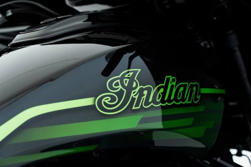 Nahaufnahme des Tanks der Indian Chieftain PowerPlus Signature Series 2026 mit grün leuchtendem „Indian-Schriftzug in Schreibschrift und mehrschichtigem Lackdesign in Venom Green und Cypher Green