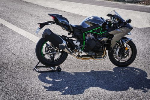 Kawasaki Ninja H2 2027 – Seitenansicht rechts auf Montageständer mit Kompressor-Motor, grünem Gitterrohrrahmen und einseitiger Schwinge