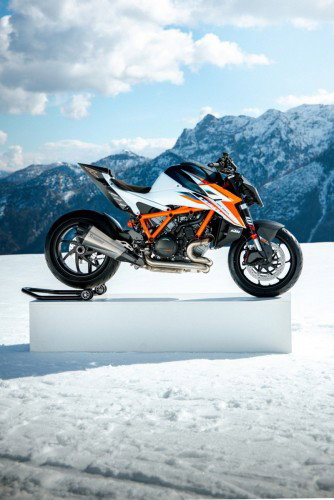 KTM 1390 Super Duke RR 2026 – Seitenansicht in Weiß-Orange auf Podest vor Alpenpanorama im Schnee