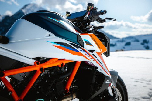 KTM 1390 Super Duke RR 2026 – Detailansicht Tank mit aerodynamischen Winglets und orangem Gitterrohrrahmen vor Alpenpanorama