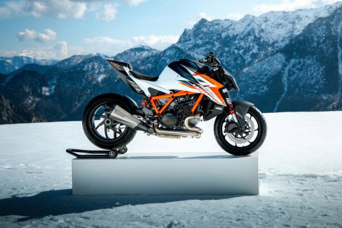 KTM 1390 Super Duke RR 2026 – Seitenansicht rechts mit Akrapovic-Titan-Endschalldämpfer auf Podest vor Alpenpanorama