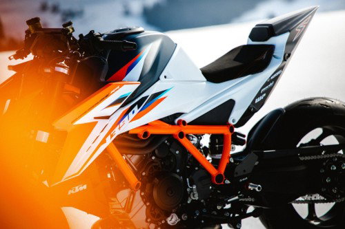 KTM 1390 Super Duke RR 2026 – Detailansicht Seitenverkleidung und Tank mit Sonnenflare und orangem Rahmen
