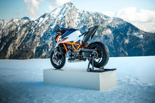 KTM 1390 Super Duke RR 2026 – Rückansicht mit Hinterradständer auf Podest im Schnee vor schneebedecktem Gipfel