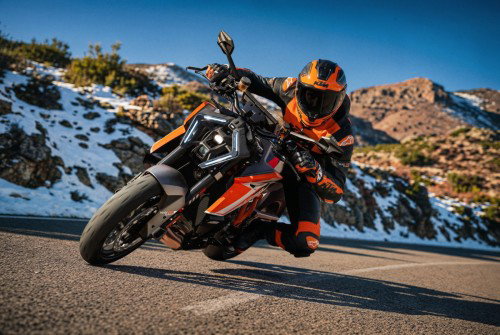 KTM 1390 Super Duke RR 2026 – Action-Aufnahme: Fahrer in Schräglage auf Landstraße vor Felsen- und Bergkulisse
