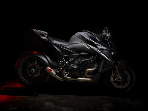 KTM 1390 Super Duke RR Track 2026 – Studioaufnahme vor schwarzem Hintergrund mit beleuchtetem Fahrwerk und sichtbarem Akrapovic-Auspuff