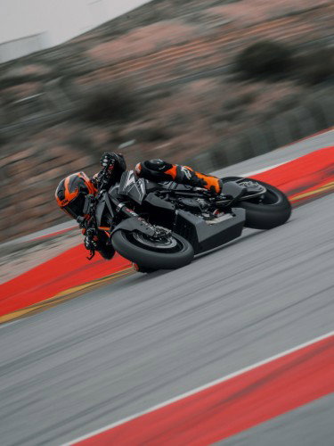 KTM 1390 Super Duke RR Track 2026 – Schräglagenfahrt auf dem Rennkurs mit orange-blauem Himmel im Hintergrund