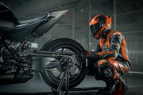 KTM 1390 Super Duke RR Track 2026 – Standaufnahme in der Boxengasse mit Fahrer im Hintergrund und dramatischem Licht