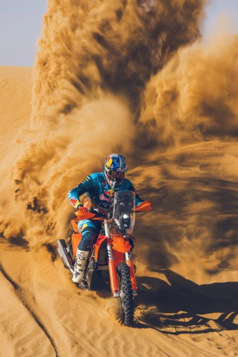 KTM 450 Rally Replica 2027 – Edgar Canet faehrt durch Sandduenen in der Wueste, Sandfahne im Hintergrund