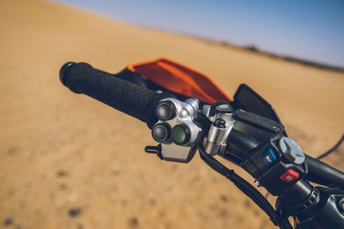 KTM 450 Rally Replica 2027 – Rally-Navigationstasten am linken Lenkergriff mit Handschuetzer und Wuestenkulisse