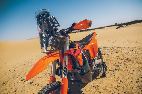 KTM 450 Rally Replica 2027 – Seitenansicht in KTM-Orange in Wuestenkulisse