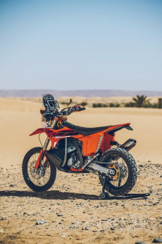 KTM 450 Rally Replica 2027 – Seitenansicht in KTM-Orange in Wuestenkulisse