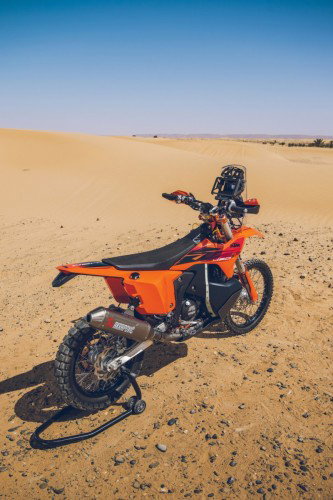 KTM 450 Rally Replica 2027 – Seitenansicht in KTM-Orange in Wuestenkulisse