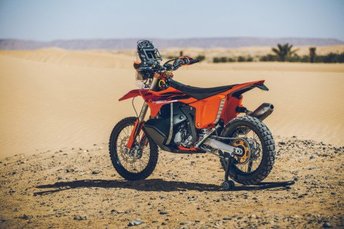 KTM 450 Rally Replica 2027 – Seitenansicht in KTM-Orange in Wuestenkulisse