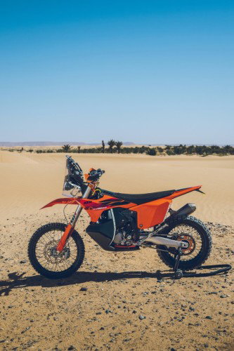KTM 450 Rally Replica 2027 – Seitenansicht in KTM-Orange in Wuestenkulisse