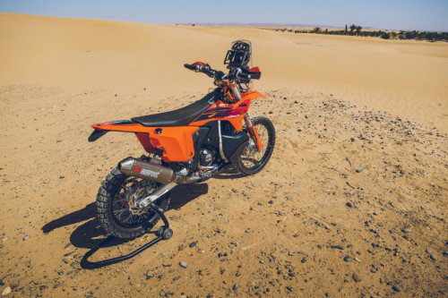 KTM 450 Rally Replica 2027 – Seitenansicht in KTM-Orange in Wuestenkulisse