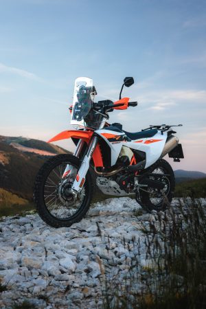 KTM 690 Rally 2027 – Ansicht 45 Grad vorn rechts auf Kalksteingeröll im Gebirge, Windschild, Fronttank und Motorschutz erkennbar