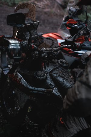 KTM 690 Rally 2027 – schlammiges Cockpit mit Windschild, Rückspiegeln und zwei Tankdeckeln, zweite Maschine dahinter