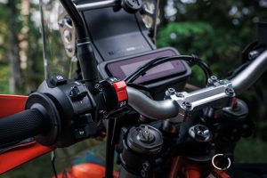 KTM 690 Rally 2027 – linke Lenkerarmatur mit rotem Tank-Umschalter und Vier-Wege-Schalter vor dem TFT-Display