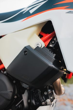 KTM 690 Rally 2027 – linker Fronttank mit Abdeckung der Kraftstoffpumpe, orangefarbenem Stahlrahmen und Auspuffkrümmer