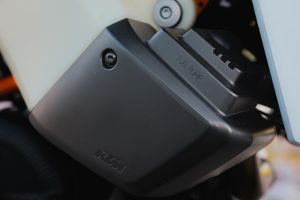 KTM 690 Rally 2027 – schwarze Kunststoffabdeckung der Kraftstoffpumpe mit KTM-Logo und Fuel-Pump-Prägung