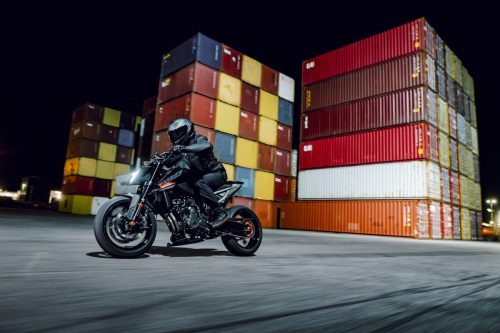 KTM 790 Duke 2027 – im Stand vor bunten Stapelcontainern bei Nacht, Fahrer im Sattel