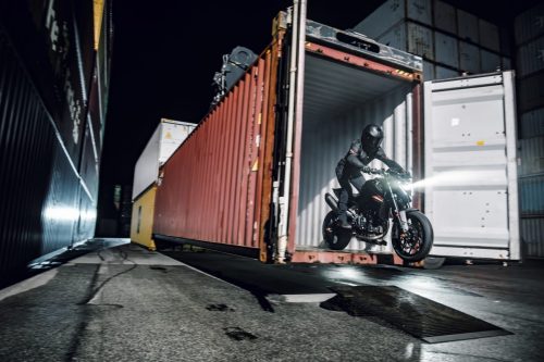KTM 790 Duke 2027 – Fahrer in einer Container-Gasse bei Nacht aus der Distanz
