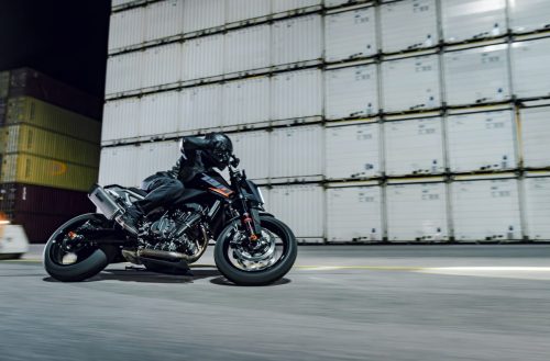 KTM 790 Duke 2027 in Action – Fahrer fährt frontal auf die Kamera zu vor Containerkulisse
