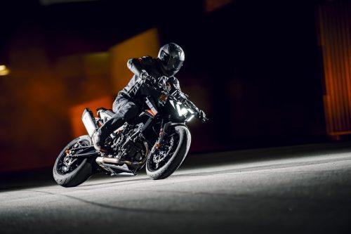 KTM 790 Duke 2027 – Fahrer in Schräglage im Containerterminal bei dramatischem Licht
