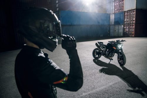 KTM 790 Duke 2027 – Fahrer setzt den Helm auf, Motorrad daneben in atmosphärischem Licht