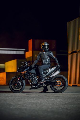 KTM 790 Duke 2027 – Fahrer im Sattel in Seitenansicht vor Containerkulisse bei Nacht
