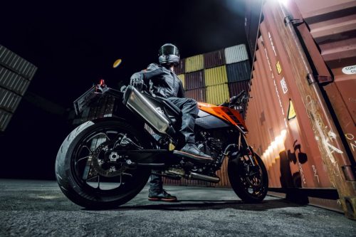 KTM 790 Duke 2027 – Fahrer auf dem Motorrad in Seitenansicht im Containerterminal