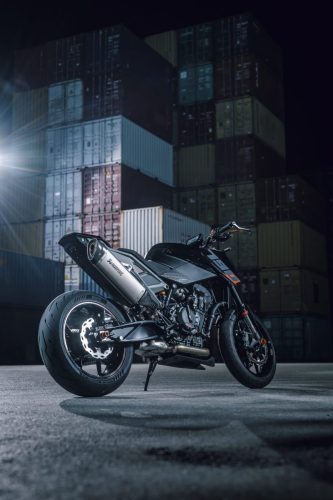 KTM 790 Duke 2027 – statische Heckansicht von links hinten vor Containerstapeln