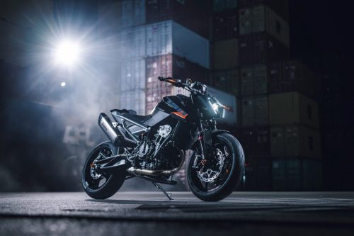 KTM 790 Duke 2027 – statische Frontansicht im Gegenlicht eines Scheinwerfers im Containerterminal