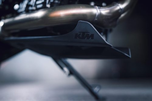 KTM 790 Duke 2027 – Detailaufnahme des Auspuffkrümmers mit Hitzeschutz und KTM-Schriftzug
