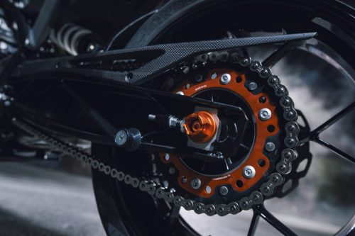 KTM 790 Duke 2027 – Detailaufnahme des orangen Kettenrads mit Kette an der Schwinge