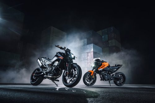 KTM 790 Duke 2027 – zwei Modelle in Orange und Schwarz im Containerterminal (Family-Shot)