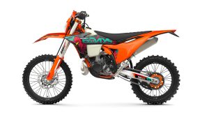 KTM 300 EXC 6DAYS 2027 – Seitenansicht von links, Zweitakt-Enduro im 6DAYS-Portugal-Design mit orange lackiertem Rahmen vor weißem Studiohintergrund