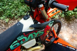 KTM 300 EXC 6DAYS 2027 – Detailansicht von Cockpit und Lenker mit Ready-to-Race-Tankgrafik